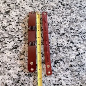 Two leather bracelets - one (smaller) red, the other (wider) brown.  EUC